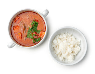 Bowl of curry with pieces of meat and a side of steamed rice arranged neatly for a meal
