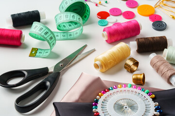 Crafting essentials for sewing projects displayed on a table with fabric, threads, and tools