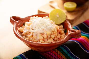 Esquites. Corn kernels cooked and served with mayo, sour cream, lemon and chili powder, very popular street food in Mexico, also known as Elote en Vaso. The recipe varies depending on the region.