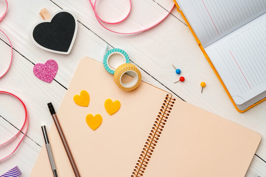 Creative workspace with colorful stationery and decorations on a white wooden desk