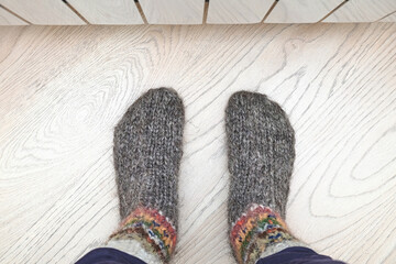 A cozy scene with Feet in warm, woolen socks by a modern radiator.