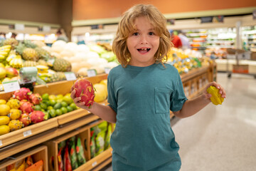 Kid with fruits. Child buying fruit in supermarket. Little boy buy fresh vegetables in grocery store. Kid choosing vegetables. Healthy food.