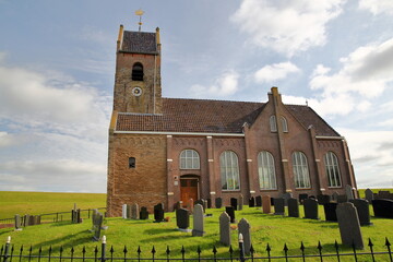 The reformed St Mary's church (Mariatsjerke) alongside the sea shore (Wadden Sea) in the terp...