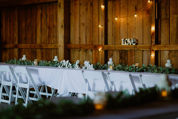 Rustic wedding reception table setup with white decor and greenery