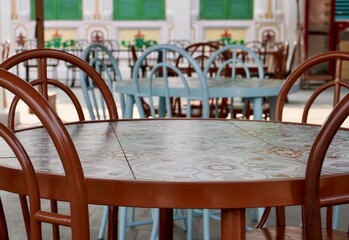 Empty outdoor restaurant or cafe table and chairs furniture isolated on horizontal ratio outdoor daytime environment background.