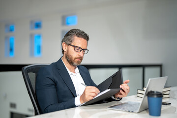 Business worker with laptop at office. Employee remote working in modern office. Business man on online meeting. Hispanic business man working online. Mature business man using laptop at workplace.