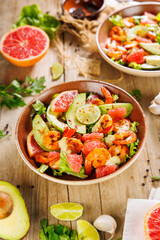 Healthy shrimp salad with avocado and grapefruit on a wooden background. Ideal for promoting vegetarian and nutritious meals