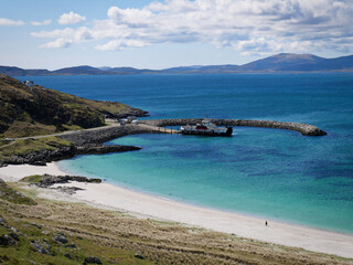 View onto the Eriskay Ferry Terminal with bright blue sea and white beach