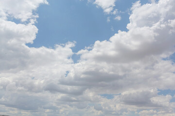 Fluffy cumulus clouds on clear sky, nature atmosphere background