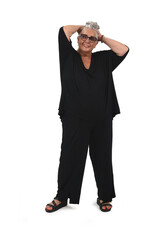 Obraz premium Front view of a senior woman standing and touching her hair on white background.