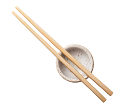 A pair of bamboo chopsticks placed across a speckled ceramic bowl. A minimalist and traditional setup for Asian cuisine dining. Isolated on transparent background, png. - Powered by Adobe