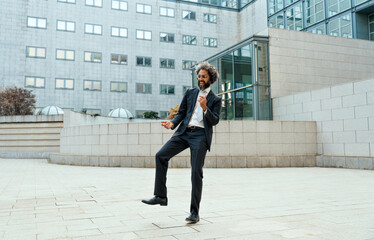 Young entrepreneur business man listening to music and dance