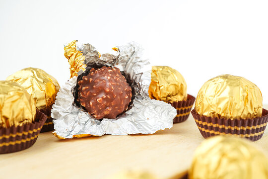 Sweet chocolate balls is made. Chocolate candy in gold wrapper on white background