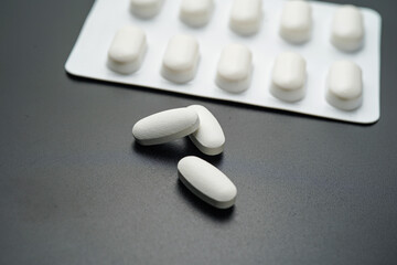 Antibiotic pills Medicine tablet capsules in blister pack on a black background