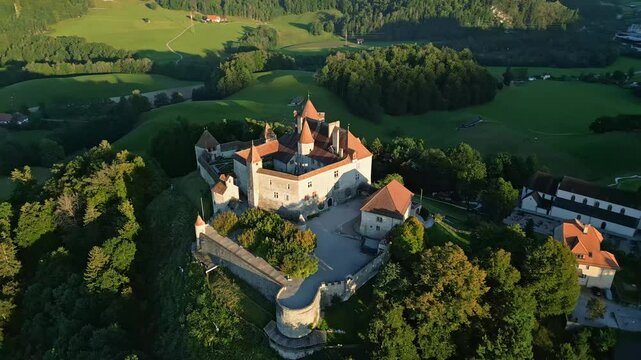 Orbit drone shot at sunset right above Gruyeres Castle in Canton of Fribourg in Switzerland.