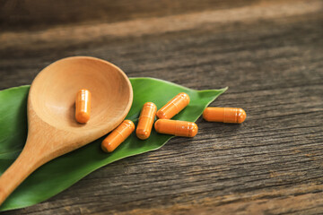 Herbal capsules from yellow tumeric on leaf for healthy eating in daily life