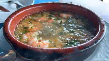 Traditional Spanish Gambas pil pil sizzling hot plate in Marbella Spain, spicy shrimp dish with garlic, 4K shot