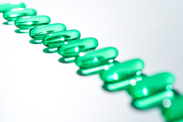 Vitamin E softgel capsules, vitamin D3, fish oil, omega 3, Green oil pills on a white background