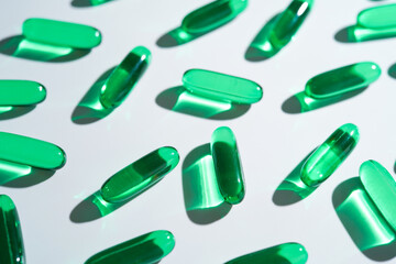 Vitamin E softgel capsules, vitamin D3, fish oil, omega 3, Green oil pills on a white background