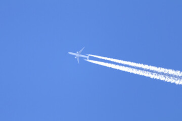 Telephoto close-up of jet plane aircraft with contrails cruising on the scottish sky