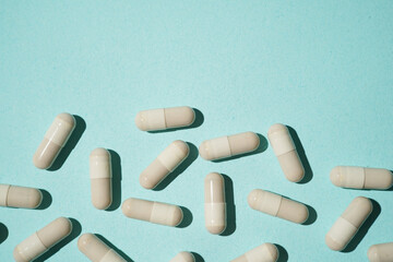 Group of pills capsules, the nutritional supplements, vitamins medicine tablets on blue background