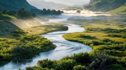 In the early morning light, a tranquil river meanders through a vibrant valley, where mist rises softly from the water's surface.