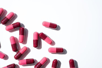 Pills, red medical capsules, antibiotic vitamins on a white background