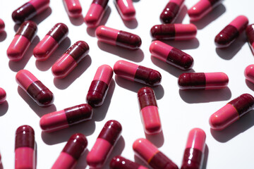 Pills, red medical capsules, antibiotic vitamins on a white background