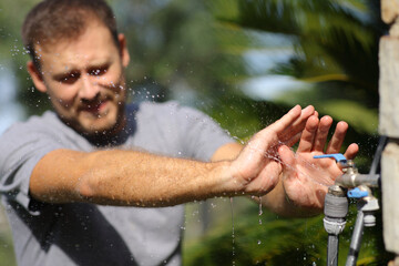 Man avoiding getting wet with a faucet leakage