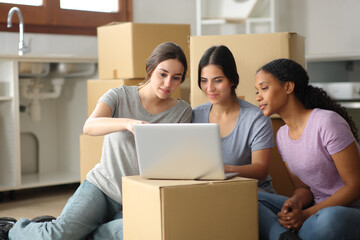 Three roommates checking laptop content moving home