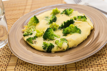 Wholesome breakfast. omelet with broccoli on brown plate