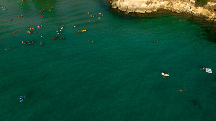 Aerial view of people bathing in the sea in Puglia, Italy. The coast is rocky in this part of the Mediterranean.