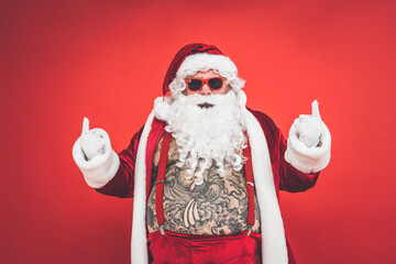 Funny crazy santa claus with tattoo having fun on a red colored background