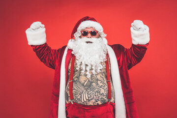 Funny crazy santa claus with tattoo having fun on a red colored background