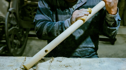 carpenter using nail gun or brad nailer tool on wood box in a workshop ,furniture restoration...