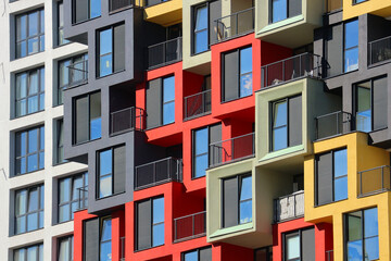 Multi-colored windows of a modern multi-story residential building.