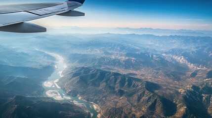 A stunning aerial view of a winding river carving through a mountain range. The image captures the beauty of nature from a unique perspective, showcasing the grandeur and vastness of the landscape.