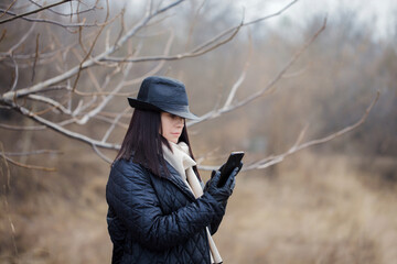 A woman wearing a hat is looking at her cell phone