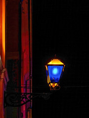 Street lamp with yellow and blue glasses. on the wall illuminated by red light at night