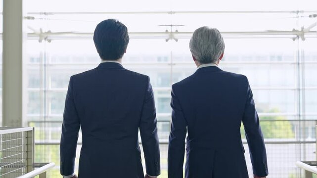 ロビーを歩く二人のビジネスパーソンの後ろ姿