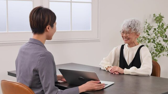 保険の営業の女性と話す高齢者の女性