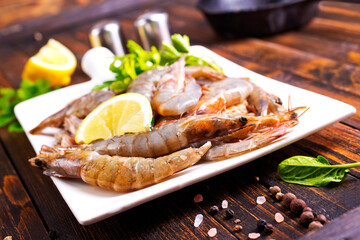 Uncooked Raw peeled tiger white shrimp prawn. Dark background.