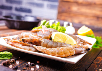 Uncooked Raw peeled tiger white shrimp prawn. Dark background.