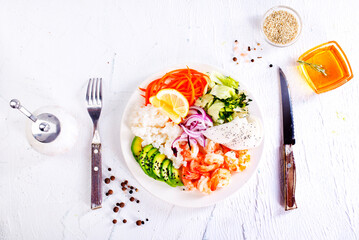 Lunch diet - rice, shrimp, avocado in one plate on a light background