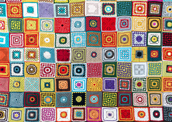 Top view of handmade multi colored plaid make from crochet granny squares with different motifs....