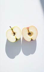 a freshly cut apple displayed in half against a solid white background, showcasing the vibrant color and juicy texture of the apple's interior and exterior in a clean and minimalist setting