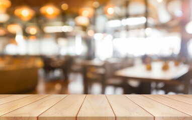 Empty wooden table top with lights bokeh on blur restaurant background.	