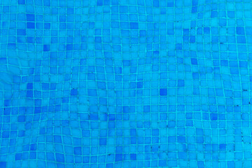 blue pool tiles under water with textured water surface gives a harmonic background