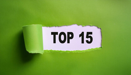 Torn paper revealing text Top 15, bright background. Business concept.