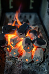 This series of three close-up images captures the mesmerizing transformation of charcoal briquettes...